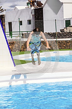 Boy jumping in the blue pool