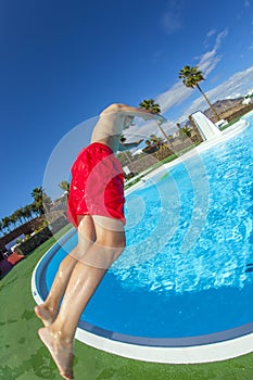 Boy jumping in the blue pool