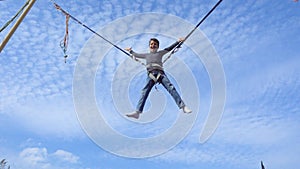 Boy jumping on bungee trampoline