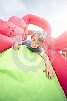 Child on inflatable bouncy castle slide