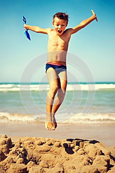Boy jumping freedom in the beach