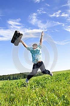 Boy jumping on a green meadow
