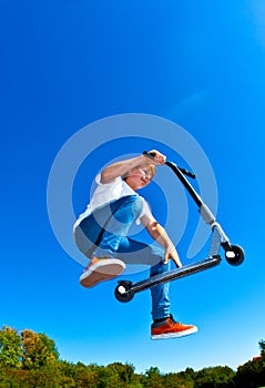 Boy jumping with his scooter
