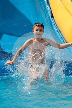 Boy jumping into an inflatable pool. Active summer vacation