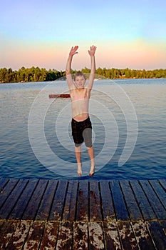 Boy jumping into lake