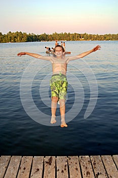 Boy jumping into lake