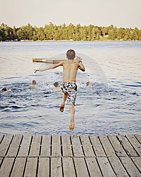 Boy jumping into lake