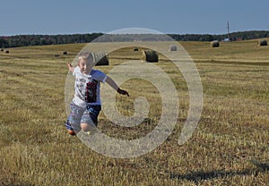 Boy jumping in near haystacks