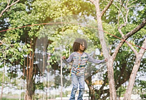 Boy jumping over the rope in the park on sunny summer day.