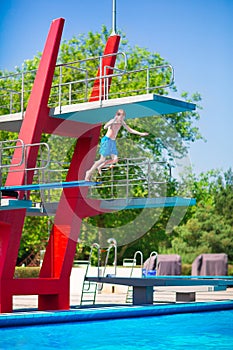 Boy jumping into a pool