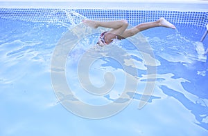 Boy jumping into the pool water