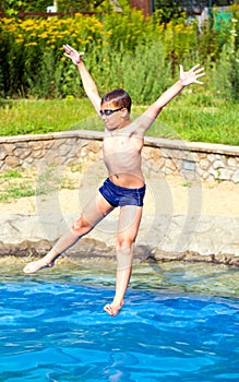 Boy jumping into a swimming pool