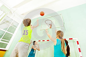 Boy jumping and throwing ball into the basket