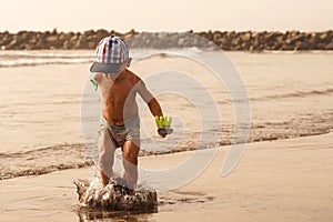 Boy jumping at tropical beach. Jumping into the air. Have a fun vacation. Sea recreation