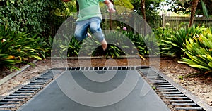 Boy jumping up and down on bouncing trampoline 4k
