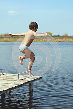 Boy jumping into water