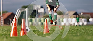Boy Jumpping Over Training Obstacles at Soccer Practice Game photo