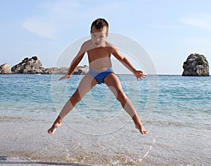 Boy jumps on beach