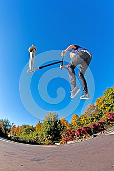 Boy jumps with his trick scooter