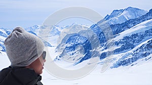 Boy is on the Jungfrau top of Europe with snow mountain background