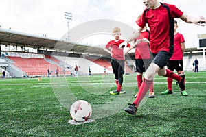 Boy Kicking Ball at Football Practice