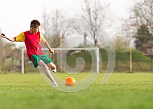 Boy kicking a ball at goal