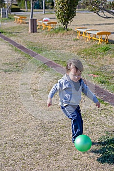 Boy Kicking Ball at Park