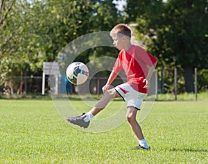 Boy kicking football