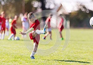 Boy kicking football on the sports field