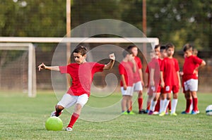 Boy kicking football on the sports field