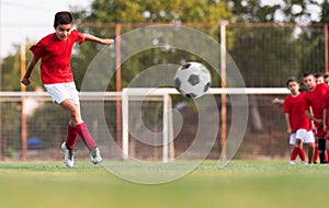 Boy kicking football on the sports field