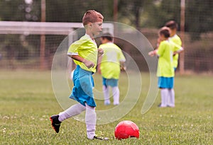 Boy kicking football on the sports field