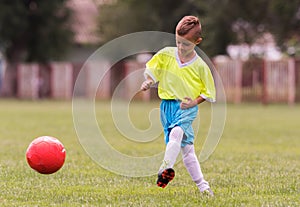 Boy kicking football on the sports field