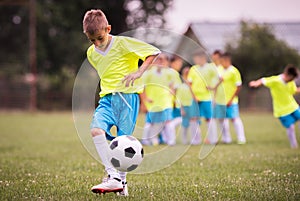 Boy kicking football on the sports field