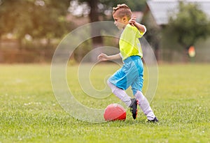 Boy kicking football on the sports field