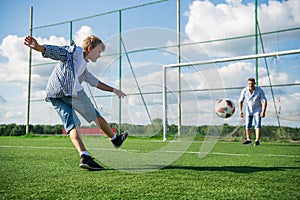 Boy kicking a penalty at goal. Low angle wide view.