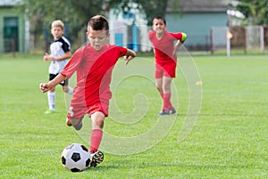 Boy kicking soccer ball photo