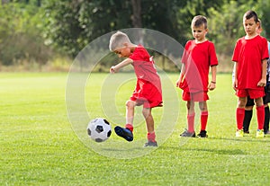 Boy kicking soccer ball at training