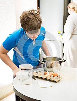 Boy kid baking muffins. Child schooler preparing muffins in the kitchen