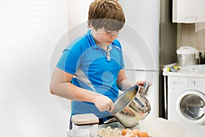 Boy kid baking muffins. Child schooler preparing muffins in the kitchen