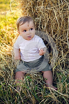 boy kid blonde in white tank top sitting on a field