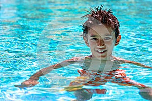 Boy kid child eight years old inside swimming pool portrait happy fun bright day