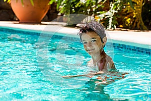 Boy kid child eight years old inside swimming pool portrait happy fun bright day