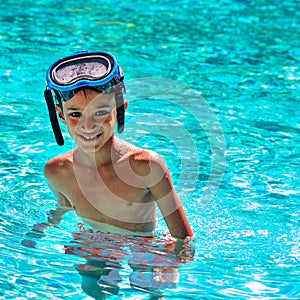 Boy kid child eight years old inside swimming pool portrait happy fun bright day diving goggles square