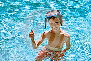 Boy kid child eight years old inside swimming pool portrait happy fun bright day diving goggles thumbs up