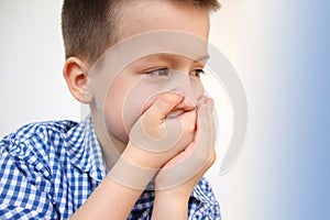 Boy, kid, covered his mouth with his palms, so as not to say anything superfluous, concept of upbringing, education, speech photo
