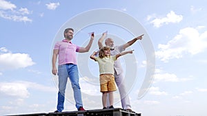 Boy kid with father and grandfather hold paper planes pointing fingers sky-high, aim