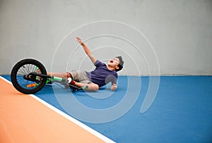 A boy kid fell of his bike in a park outdoors