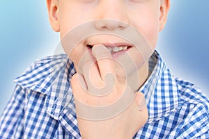 Boy, kid nibbles and bites a nail on his hand, close-up, the concept of psychological disorder, stress, bad childhood habits