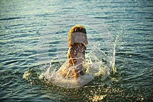 Boy kid playing on the beach on summer holidays. Child in nature with beautiful sunset sea. Happy kids on vacations at